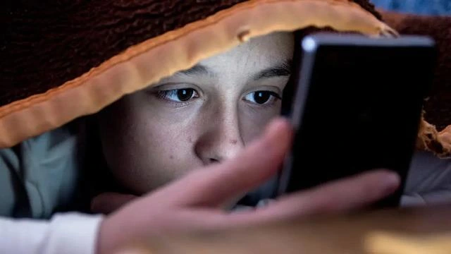 Telefon ekranına bakan bir çocuk