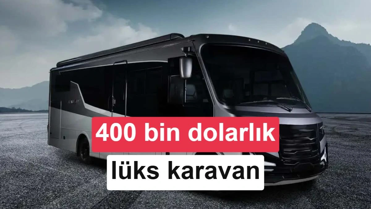 Dağlık bir manzara önünde duran büyük, siyah ve beyaz lüks karavan