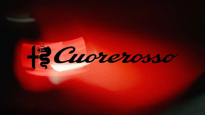 Kırmızı ışıkla aydınlatılmış Cuorerosso yazısı ve Alfa Romeo amblemi