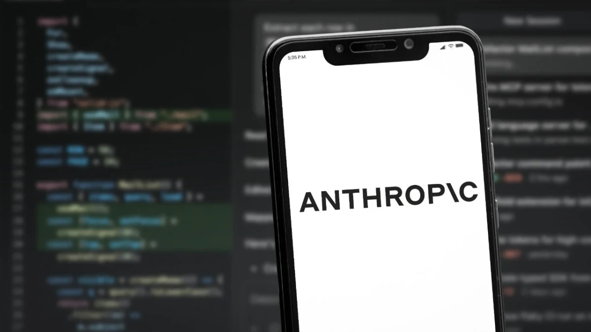 Ekranında ANTHROPIC yazısı bulunan bir telefon, arka planda kod görüntüleri