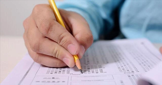Bir kişi sınav cevap formunda kurşun kalemle işaretleme yapıyor.