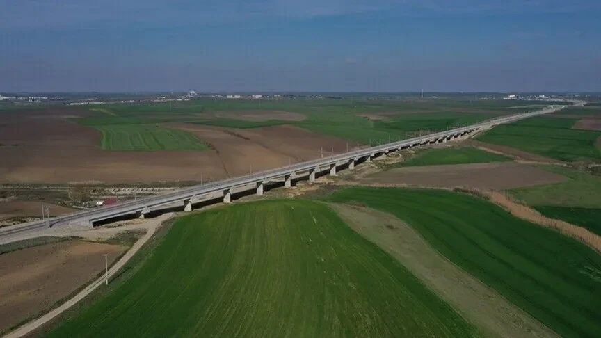 Tarım arazileri arasından geçen yükseltilmiş demir yolu hattı