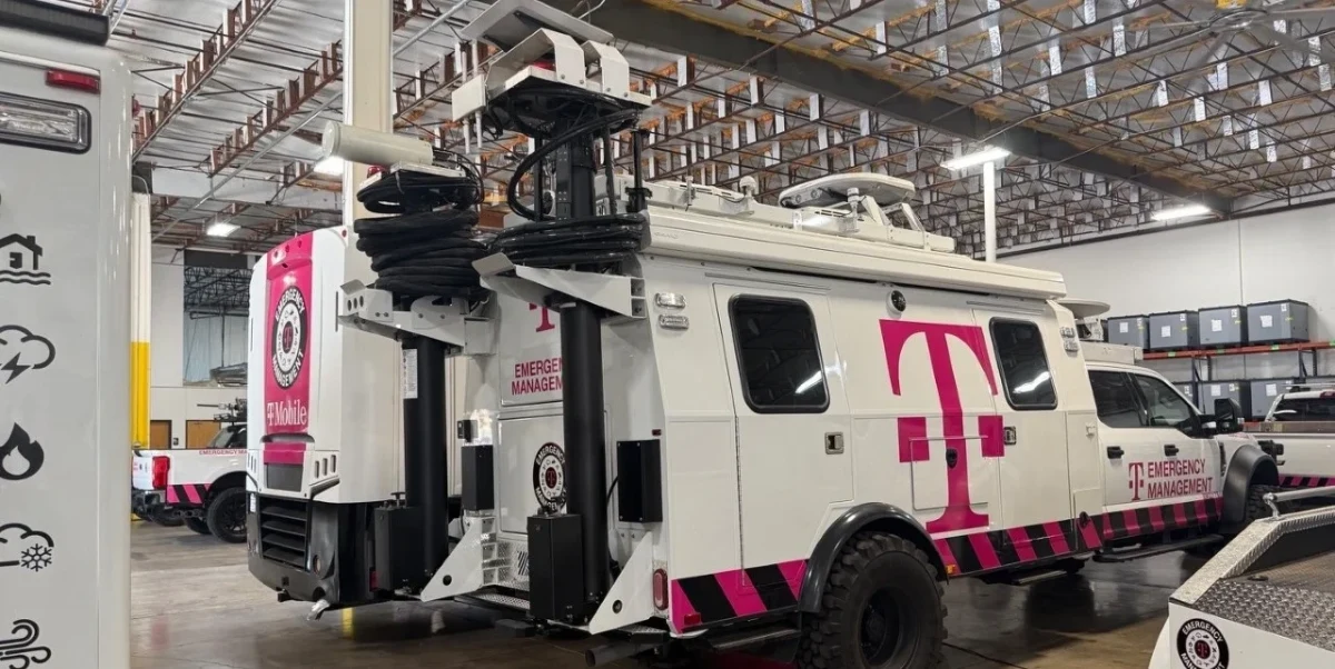 T-Mobile logolu bir araç ve telekomünikasyon ekipmanları bulunan kapalı bir tesis