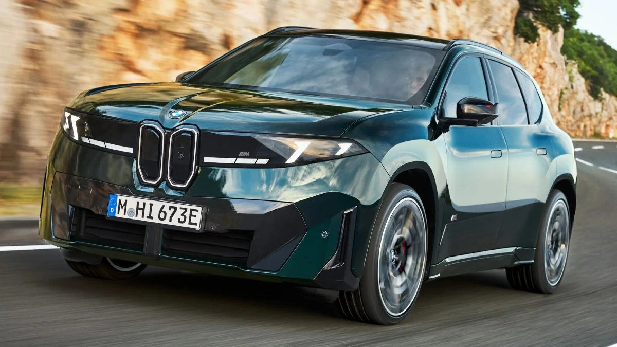 Yolda ilerleyen koyu yeşil BMW iX3 M60 xDrive