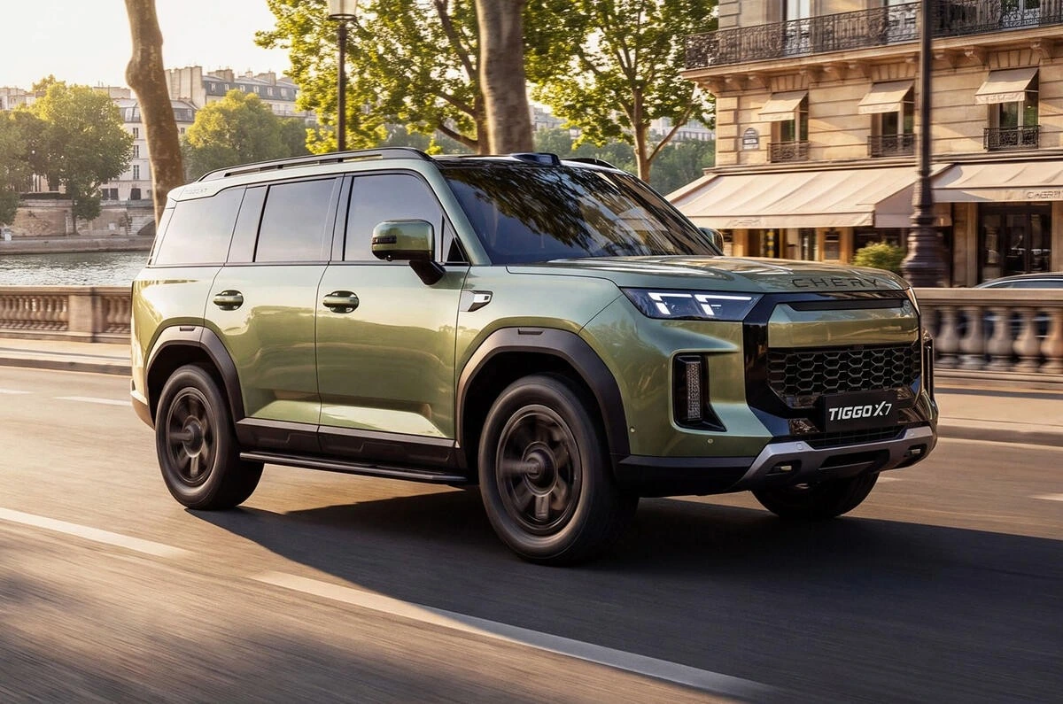 Yeşil Chery Tiggo X7 şehir caddesinde ilerlerken