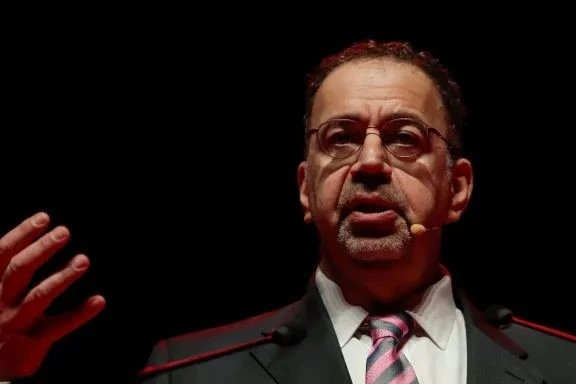 Daron Acemoğlu sahnede konuşurken elini kaldırıyor