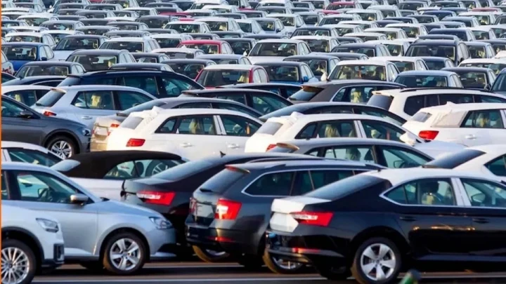 Yoğun bir otoparkta yan yana sıralanmış farklı marka ve modellerde otomobiller