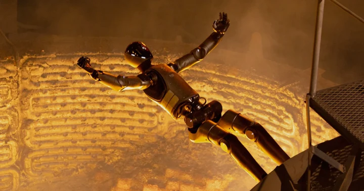 Figure F.02 insansı robotu, turuncu ışıkla aydınlanan büyük bir döküm ocağının içinde havada görülüyor