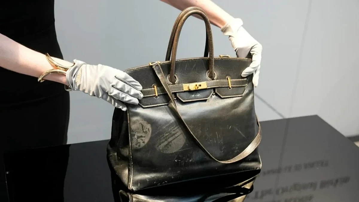 Eldivenli ellerin tuttuğu siyah Birkin çanta