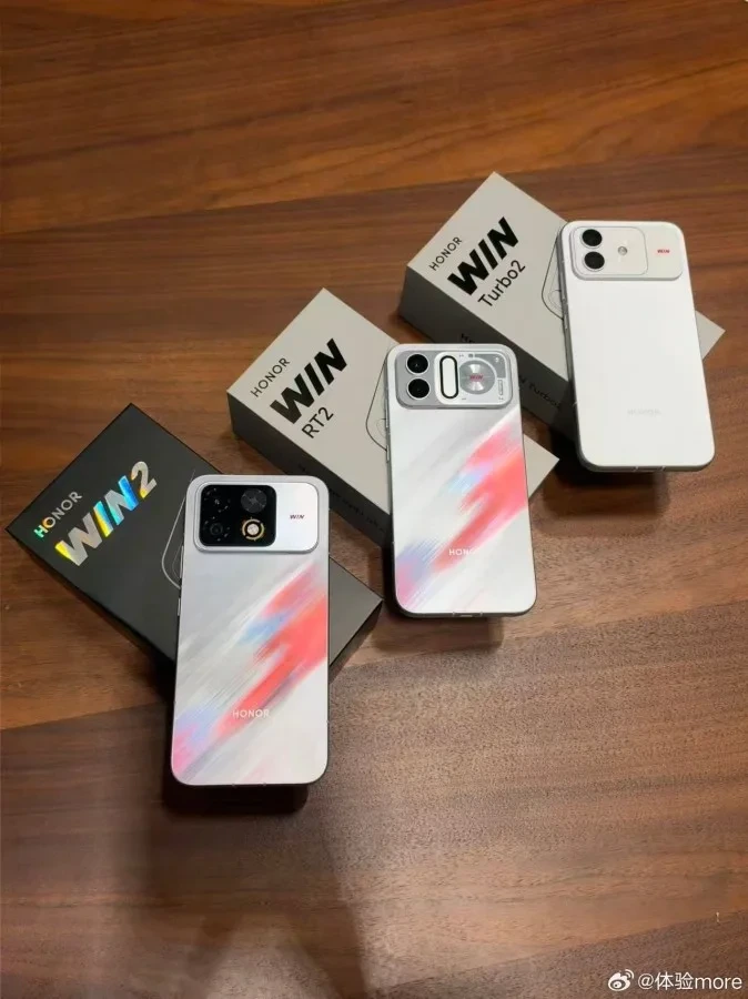 Honor Win 2 serisindeki üç telefon, kutularıyla birlikte ahşap bir yüzey üzerinde yan yana duruyor