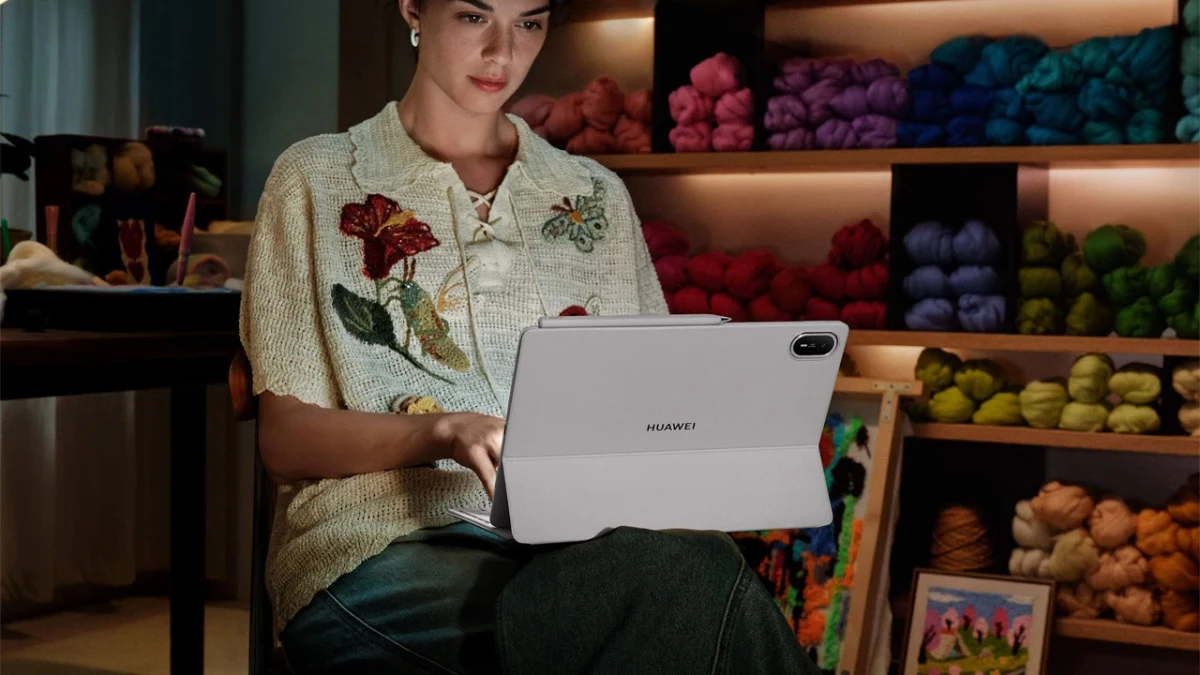 Bir kişi otururken açık renkli Huawei tablet kullanıyor.