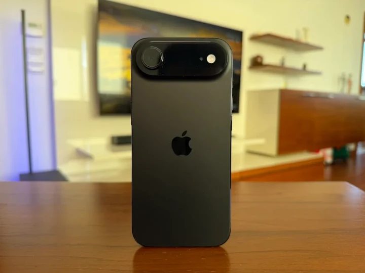 Masa üzerinde arka yüzü görünen siyah iPhone