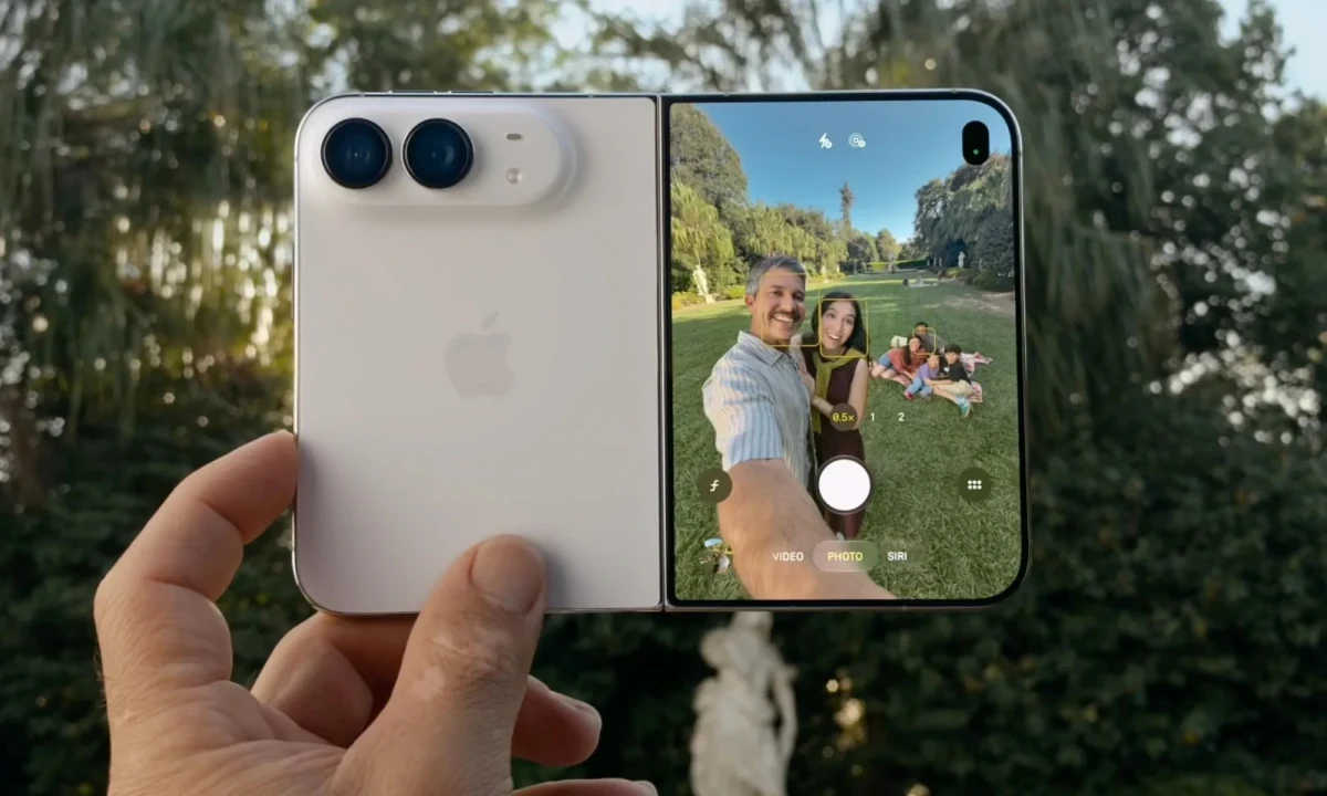 Bir elde tutulan açık iPhone Duo’nun arka kamerası ve ekrandaki fotoğraf çekim arayüzü