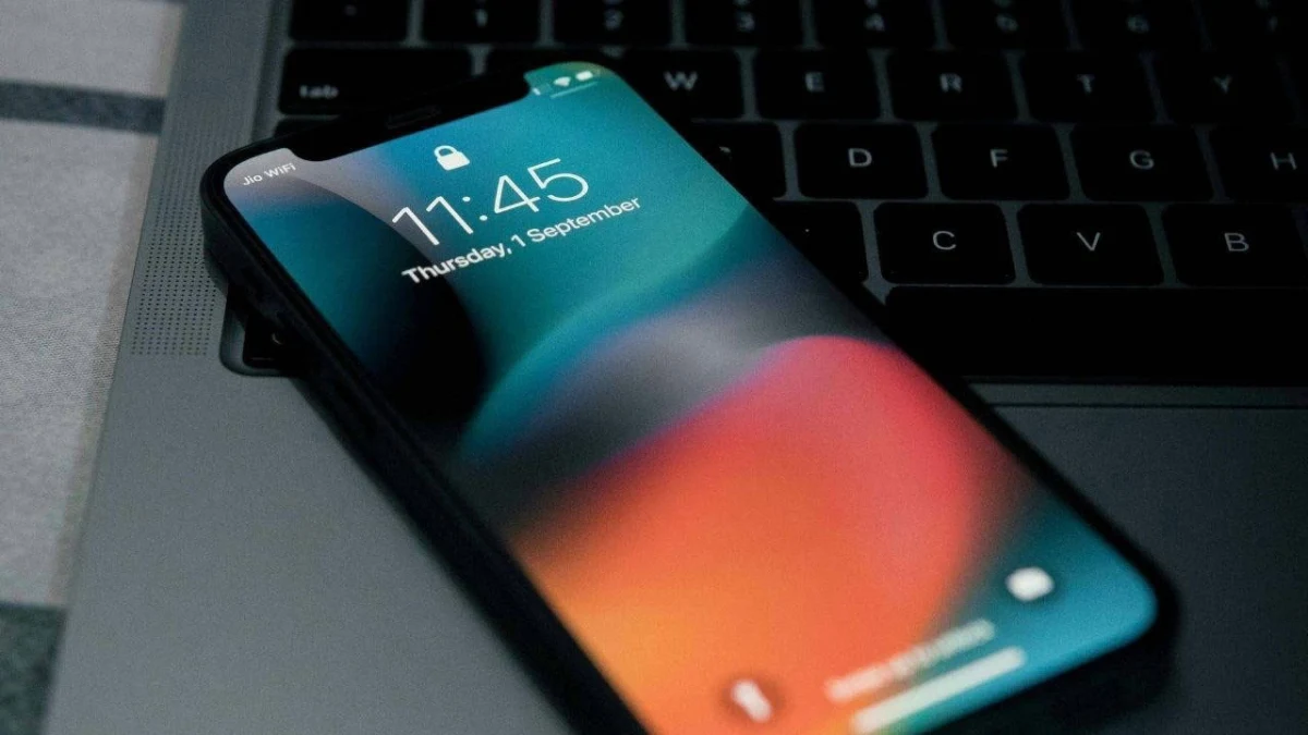Klavyenin üzerinde duran iPhone’un ekranında saat ve tarih görünüyor.