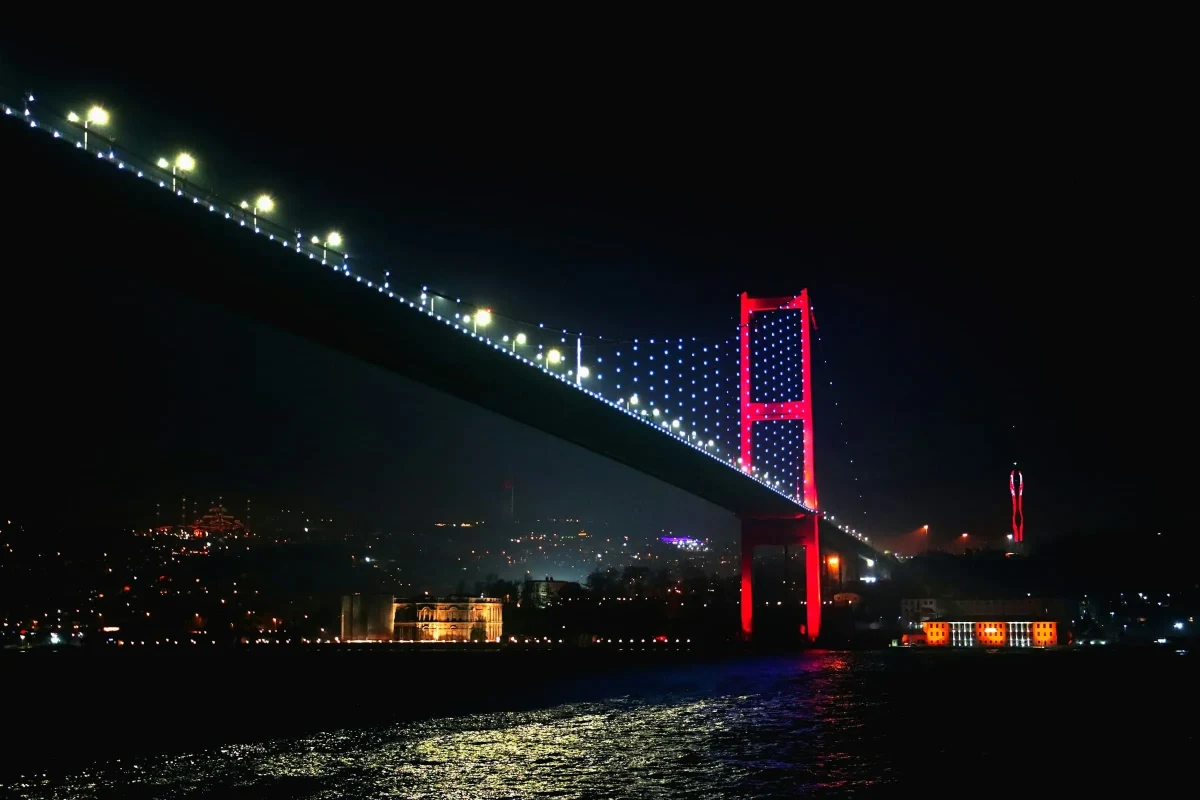 Gece ışıklandırılmış Boğaziçi Köprüsü ve İstanbul silüeti
