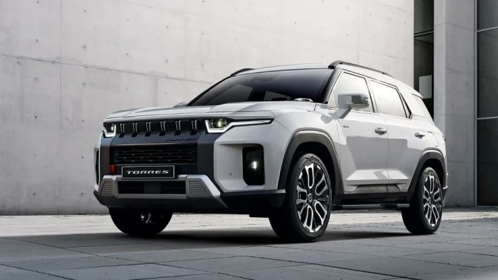 Açık renkli KGM Torres SUV, beton duvar önünde park hâlinde