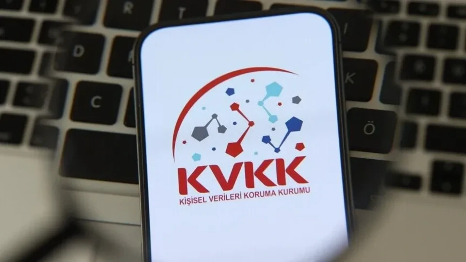 Klavye önünde ekranda KVKK logosu bulunan akıllı telefon