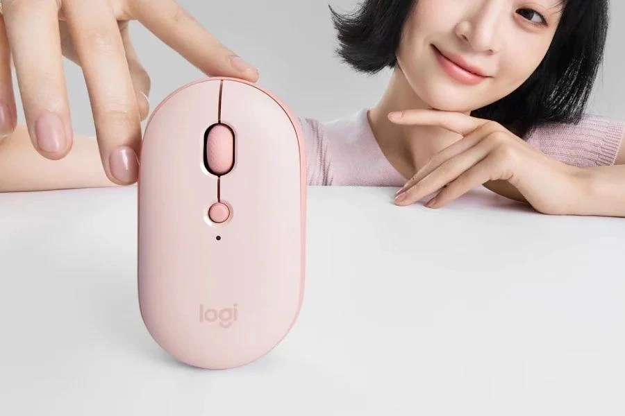 Pembe Logitech Pebble Up fare masada dururken yanında bir kişi görülüyor