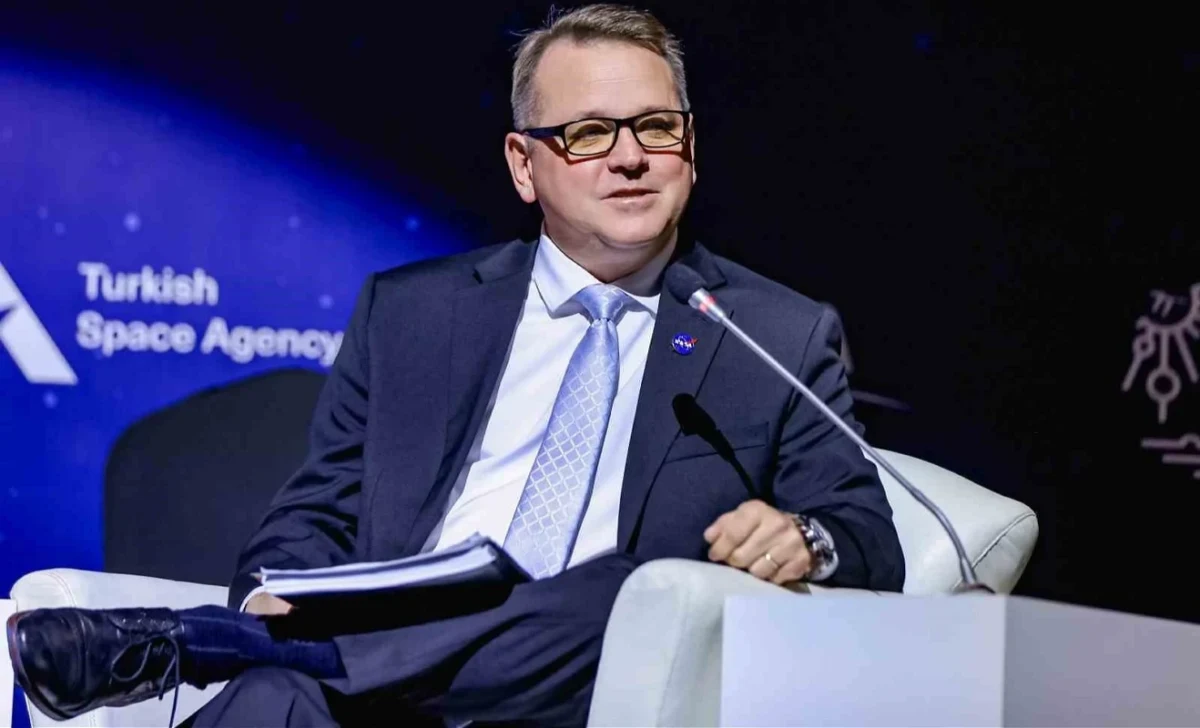 TUA yazılı arka plan önünde konuşan Matt Anderson