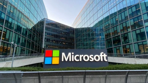 Microsoft yazısının yer aldığı tabela, cam cepheli ofis binalarının önünde görülüyor.