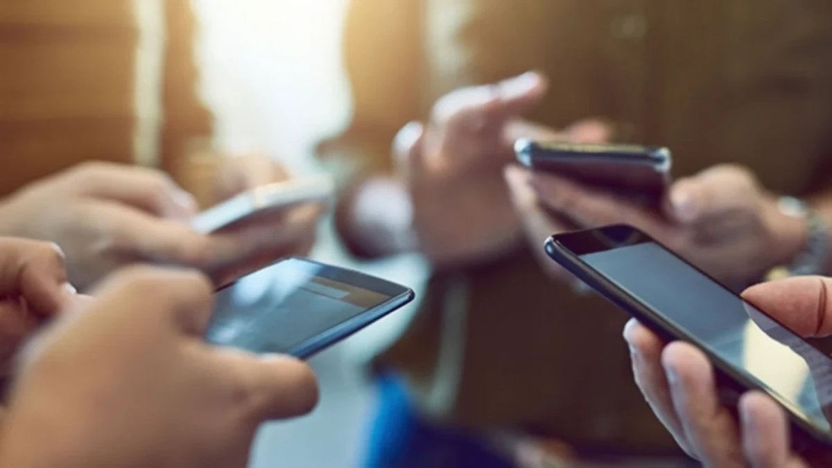 Bir arada bulunan kişilerin akıllı telefon ve tablet kullandığı görüntü