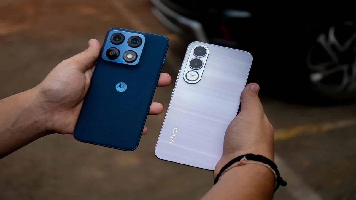 Bir kişinin elinde tuttuğu Motorola ve Vivo telefonlar