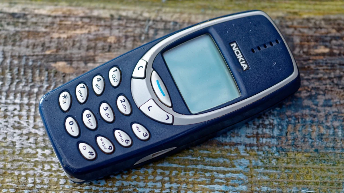 Mavi Nokia 3310 cep telefonu, dokulu bir yüzey üzerinde duruyor