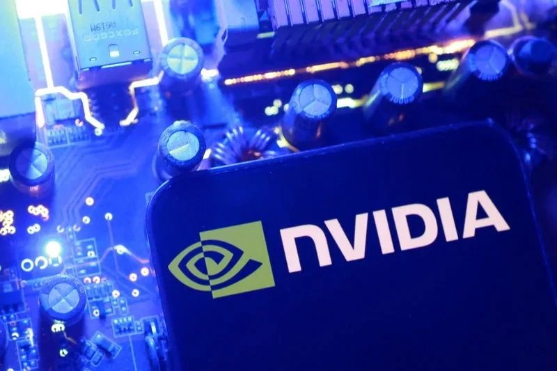 NVIDIA logosunun yer aldığı bir çip, mavi ışıklarla aydınlatılmış elektronik devre kartı üzerinde görülüyor