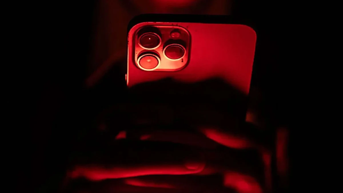Kırmızı ışıkla aydınlatılmış bir iPhone’un arka yüzü