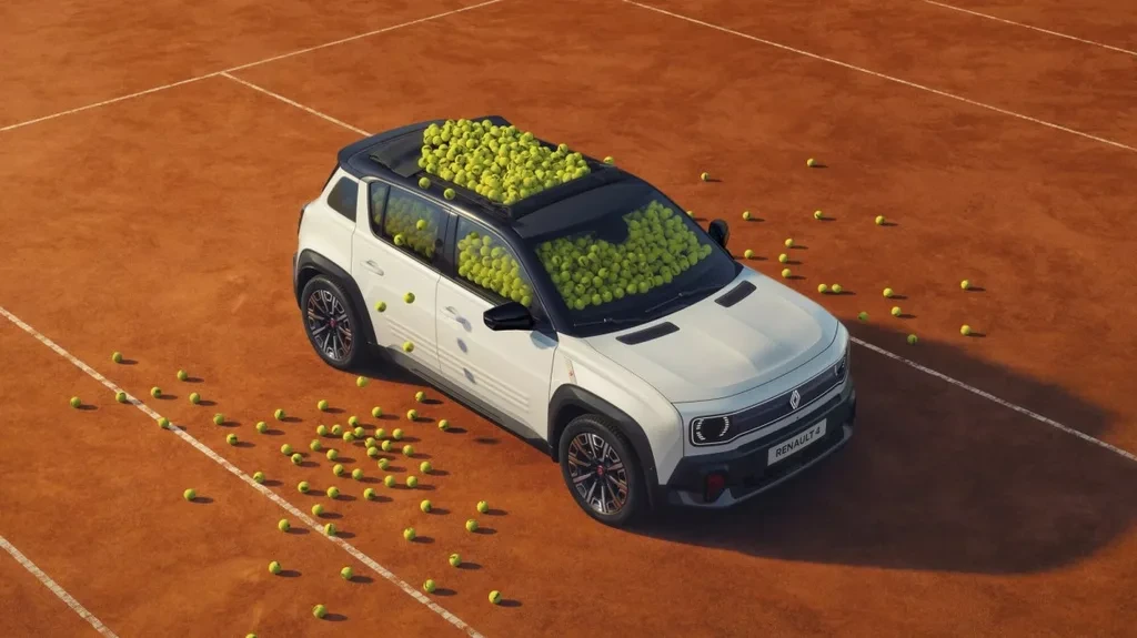 Renault 4 E-Tech, toprak kortta tenis toplarıyla çevrili halde