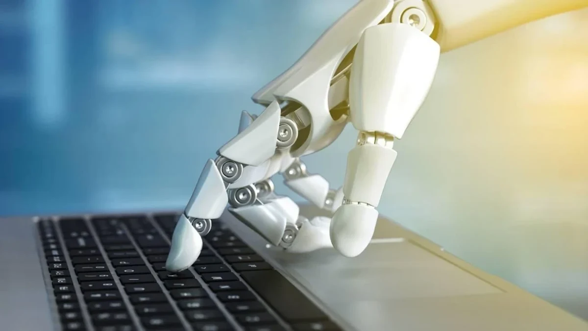 Dizüstü bilgisayar klavyesine dokunan robot eli