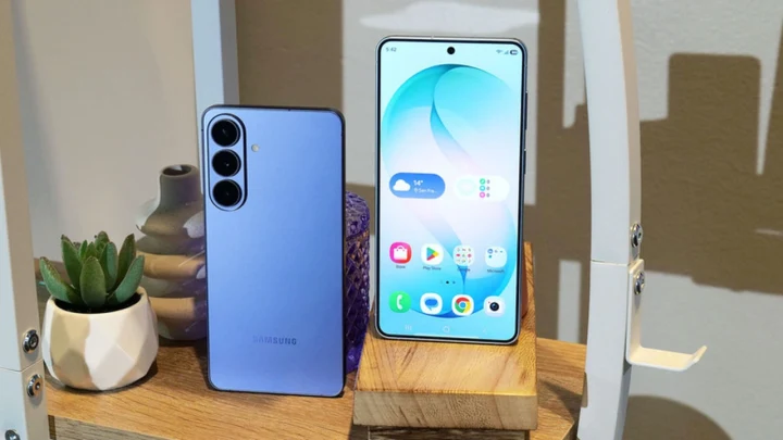 Masa üzerinde yan yana duran mavi renkli Samsung telefonlar