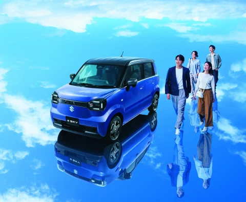 Suzuki eSKY elektrikli otomobili ve aracın yanında yürüyen dört kişi