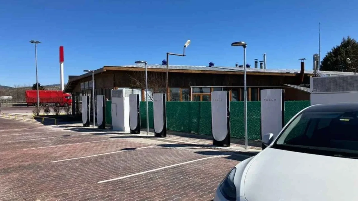 Trabzon’daki Tesla Supercharger istasyonunda sıralanan şarj üniteleri ve sağda beyaz bir otomobil