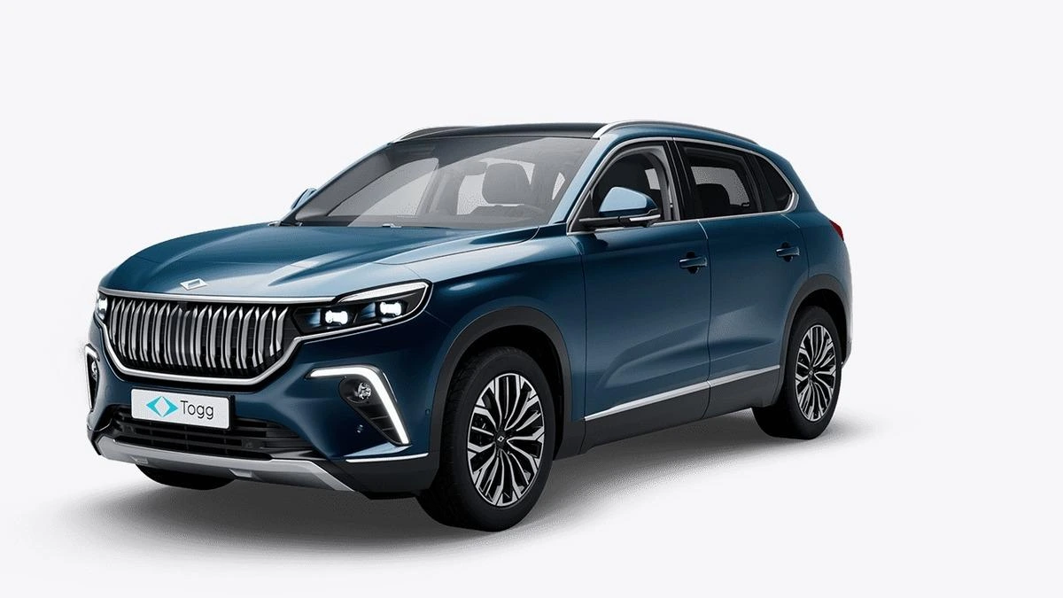 Koyu mavi Togg T10X elektrikli SUV, beyaz fonda önden ve yandan görünüyor