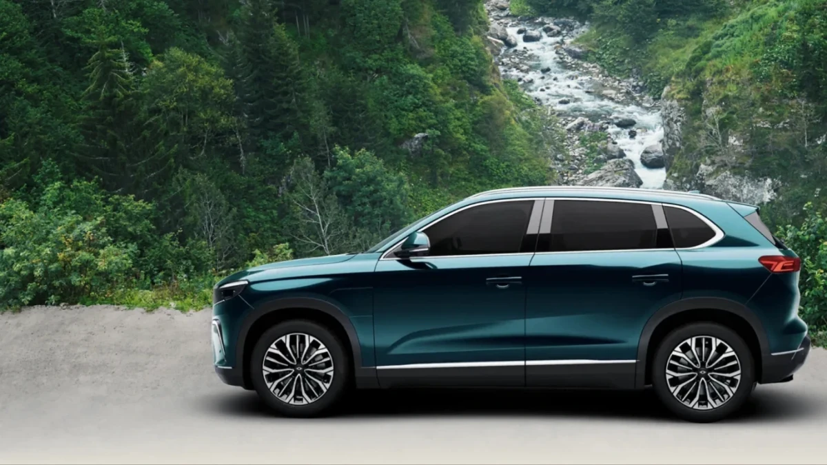 Ormanlık alan ve dere önünde yandan görünen turkuaz renkli Togg SUV
