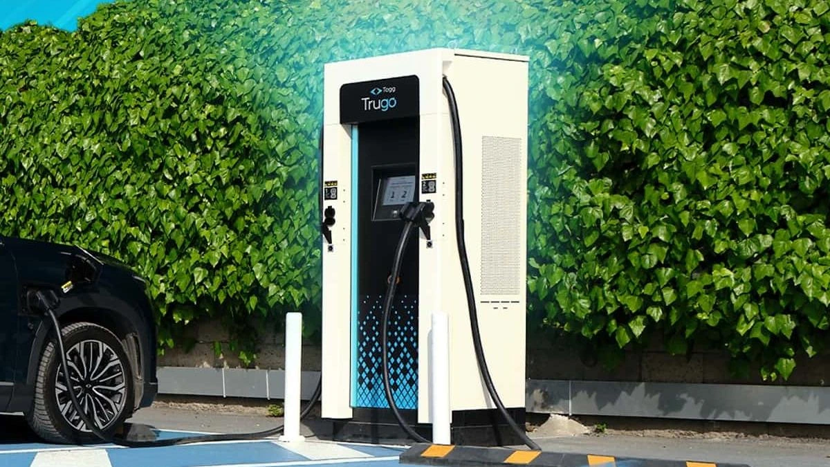 Bir Trugo şarj cihazı ve yanında park etmiş elektrikli otomobil