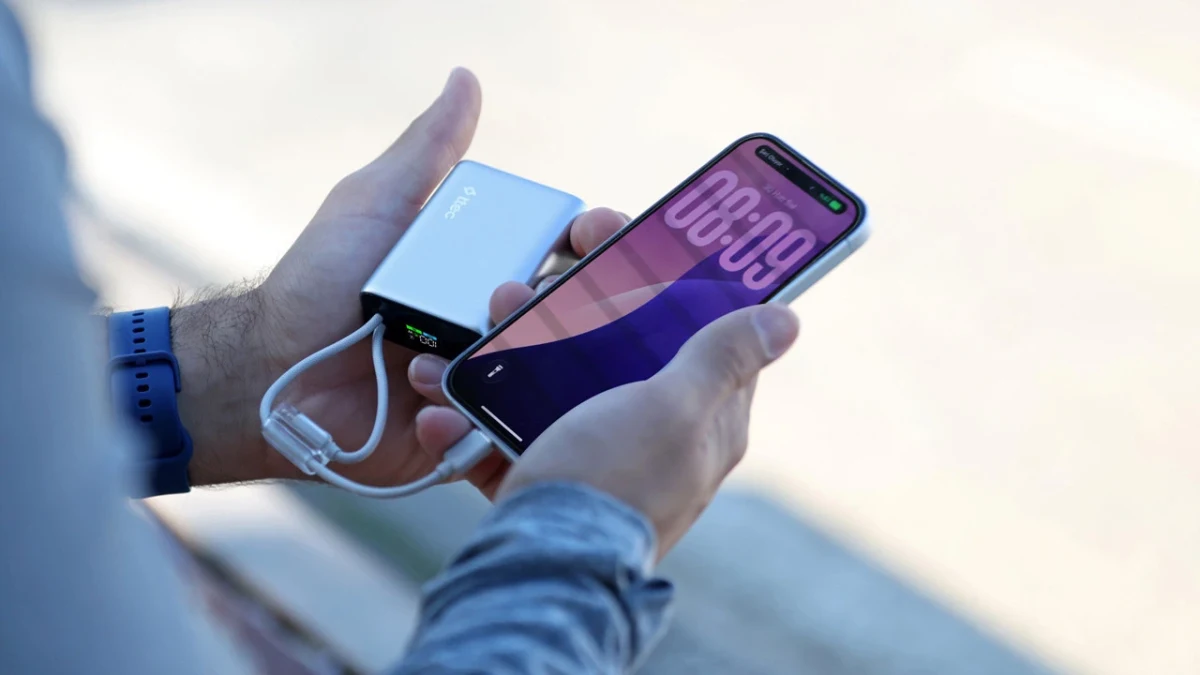 Bir kişi elinde powerbank ve akıllı telefon tutuyor; telefon powerbank’e bağlı kabloyla şarj ediliyor.