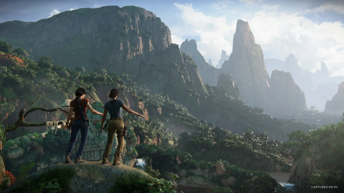 Uncharted: The Lost Legacy’den bir sahnede iki karakter, yeşil dağların ve vadinin manzarasına bakıyor.