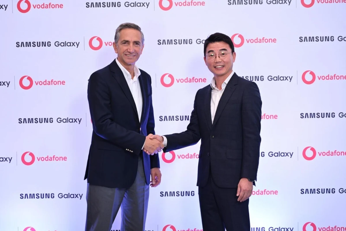 Vodafone ve Samsung logolarının yer aldığı fonda Engin Aksoy ile Billy Kim tokalaşıyor