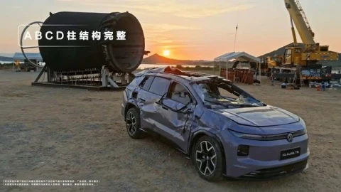 Test sonrası ezilmiş gövdesi görülen Volkswagen ID. AURA T6, büyük silindirik tamburun önünde duruyor.